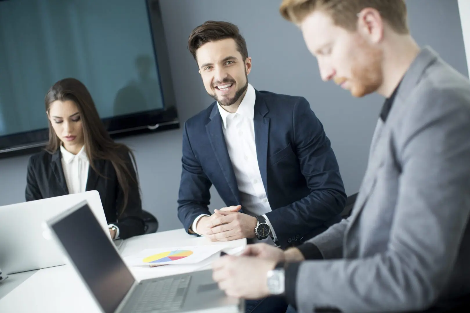 Business professionals engaged in a meeting around a conference table.